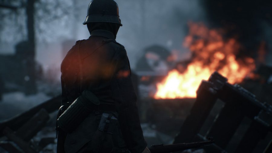 カメラの前に立っている兵士が、遠くに火を放ちながら戦場を見渡しています。