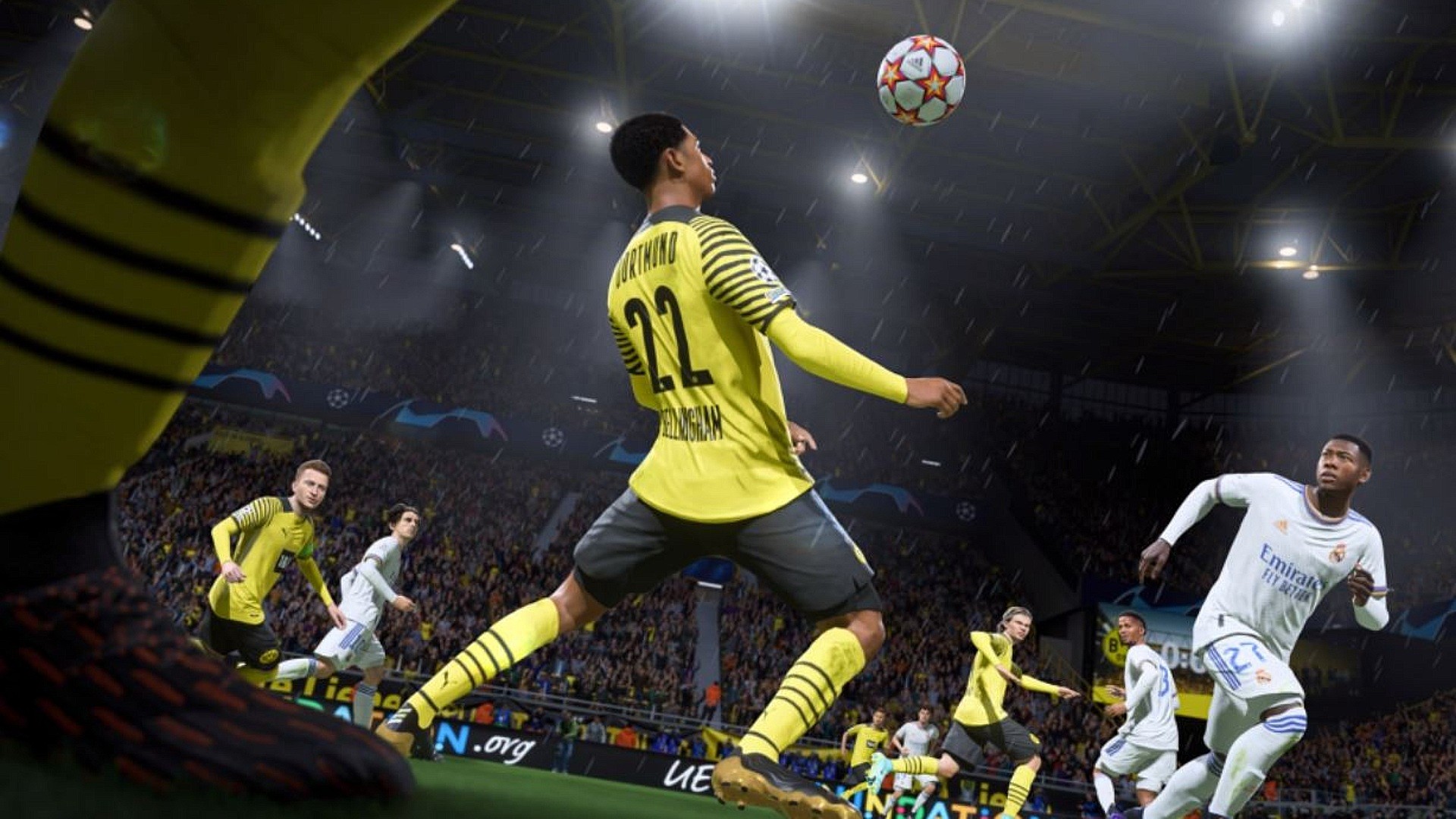最高のPS5マルチプレイヤーゲーム：黒と黄色のキットを身に付けたボルシアドルトムントの選手が、FIFA22で胸を使ってサッカーをコントロールする準備をしています