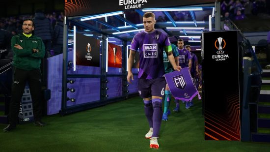 最高のフットボール ゲーム: Football Manager 2023 で紫色のユニフォームを着たキャプテンが選手たちをトンネルから導き出す