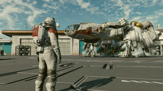 スターフィールドの船: 宇宙服を着て宇宙港で自分の船を眺めるプレイヤー。